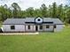 Charming modern farmhouse with black trim, natural wood accents, and lush green lawn at 12193 Sw 69 Pl, Ocala, FL 34481