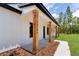 Charming front porch showing stained wood columns, house number, board and batten siding, and professional landscaping at 12193 Sw 69 Pl, Ocala, FL 34481