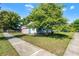 Single-Gathering home featuring a detached garage, verdant lawn, and mature tree offering ample shade at 1225 W Smith St, Orlando, FL 32804