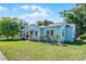 Quaint one-story home with a colorful exterior, mature landscaping, and a charming pink front door at 1225 W Smith St, Orlando, FL 32804