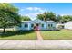Inviting single-Gathering home with a well-manicured lawn, brick pathway, pink door, and lush surrounding trees at 1225 W Smith St, Orlando, FL 32804