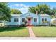 Charming single-Gathering home featuring a beautiful lawn, brick walkway, and eye-catching pink door at 1225 W Smith St, Orlando, FL 32804