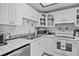 Well-lit kitchen with white cabinets, tile backsplash, and modern appliances at 1225 W Smith St, Orlando, FL 32804