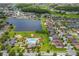 Community aerial view showing a pool and a neighborhood surrounded by lush landscaping and a lake at 12845 Sawgrass Pine Cir, Orlando, FL 32824