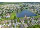 Aerial view of homes in a community with lake featuring single-story home in the foreground and a community pool at 12845 Sawgrass Pine Cir, Orlando, FL 32824