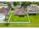 Aerial view of the backyard showcasing an expansive grassy area, screened in porch and white picket fence at 12845 Sawgrass Pine Cir, Orlando, FL 32824