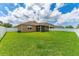 Large backyard featuring a lush lawn, privacy fence, and screened-in lanai at 12845 Sawgrass Pine Cir, Orlando, FL 32824