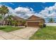 Single-story home featuring a two-car garage, complemented by landscaped bushes and a concrete driveway at 12845 Sawgrass Pine Cir, Orlando, FL 32824