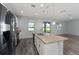 An open kitchen with stainless steel appliances, an island, and a view to the backyard at 12845 Sawgrass Pine Cir, Orlando, FL 32824