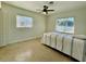 A bedroom with two windows, blinds, a ceiling fan, and a bed with striped bedding at 1326 Edmundshire Ln, Orlando, FL 32806