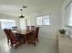 Dining room with a wooden table, chairs, and natural light from the surrounding windows at 1326 Edmundshire Ln, Orlando, FL 32806