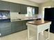 Functional kitchen with gray cabinetry, marble countertops, and an island at 1326 Edmundshire Ln, Orlando, FL 32806