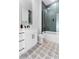 Stylish bathroom featuring a glass-enclosed shower with green subway tile, patterned tile floor, and white vanity at 13393 Sw 484 Hwy, Ocala, FL 34481