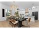 Open-concept dining area with modern chandelier, sleek dining table, and adjacent kitchen with white cabinets at 13393 Sw 484 Hwy, Ocala, FL 34481