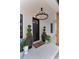 Inviting front door entrance with an elegant chandelier, decorative plants, and modern black accents at 13393 Sw 484 Hwy, Ocala, FL 34481