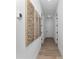 Bright hallway with wood flooring, white walls, and interesting modern art pieces at 13393 Sw 484 Hwy, Ocala, FL 34481