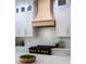 A bright modern kitchen with white cabinets, a gas range with gold knobs, and a light wood range hood at 13393 Sw 484 Hwy, Ocala, FL 34481