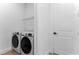 Bright laundry room features modern appliances, white door, wire shelving and hard wood floors at 13393 Sw 484 Hwy, Ocala, FL 34481