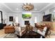 Bright living room with fireplace, modern fan, leather furniture, hard wood floors, and modern decor at 13393 Sw 484 Hwy, Ocala, FL 34481