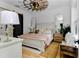 Comfortable bedroom featuring a wooden windmill ceiling fan, natural light, and charming decor at 13393 Sw 484 Hwy, Ocala, FL 34481