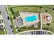 Aerial view of the community pool, playground, parking, and lush green spaces at 1396 Mirabella Cir, Davenport, FL 33897