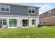 A home's backyard with a lush green lawn and gray and white siding at 1396 Mirabella Cir, Davenport, FL 33897