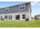 Backyard featuring a lush green lawn, gray siding, and sliding glass doors at 1396 Mirabella Cir, Davenport, FL 33897