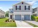 Charming two-story home with gray siding, two-car garage, and meticulously landscaped front yard at 1396 Mirabella Cir, Davenport, FL 33897