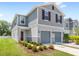 Charming two-story home with gray siding, two-car garage, and meticulously landscaped front yard at 1396 Mirabella Cir, Davenport, FL 33897