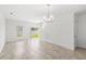 Bright living room with tile floors, a modern chandelier, and sliding glass doors to the backyard at 1396 Mirabella Cir, Davenport, FL 33897