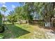 Large backyard with mature trees, lush green grass, and a privacy fence at 14 Sequoia Way, Kissimmee, FL 34758