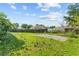 A large grassy backyard with a concrete slab and a distant view of the home at 14 Sequoia Way, Kissimmee, FL 34758