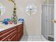 Bathroom with a modern vanity, octagonal window, and glass enclosed shower at 14 Sequoia Way, Kissimmee, FL 34758
