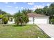 Charming single-story home featuring a two-car garage, manicured lawn, and mature palm trees at 14 Sequoia Way, Kissimmee, FL 34758
