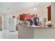Well-lit kitchen featuring granite countertops, white tile flooring, and wooden cabinetry, enhanced with barstool seating at 14 Sequoia Way, Kissimmee, FL 34758