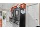 Bright kitchen featuring stainless steel appliances, a refrigerator with a magnetic noticeboard, and paneled cabinets at 14 Sequoia Way, Kissimmee, FL 34758