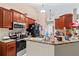 Functional kitchen featuring granite countertops, modern appliances, and cabinetry with a view into another living space at 14 Sequoia Way, Kissimmee, FL 34758