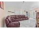 Comfortable living room featuring a plush leather sectional and tile flooring throughout at 14 Sequoia Way, Kissimmee, FL 34758