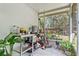 Screened porch with metal shelving, plants, and backyard view at 14 Sequoia Way, Kissimmee, FL 34758