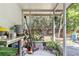 View of the tiled and screened back porch with plants and a partial view of the backyard at 14 Sequoia Way, Kissimmee, FL 34758