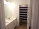 Bright bathroom featuring double sinks, white cabinetry and a bathroom with striped curtain at 14955 Lebeau Loop, Winter Garden, FL 34787