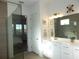 Bright bathroom features white cabinetry, neutral tiling, glass shower, and a view to the bedroom at 14955 Lebeau Loop, Winter Garden, FL 34787