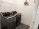 Laundry room with full size washer and dryer and overhead shelving at 14955 Lebeau Loop, Winter Garden, FL 34787