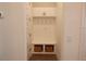 Functional mudroom features built-in storage, including hooks, a bench, and baskets, enhancing organization at 14955 Lebeau Loop, Winter Garden, FL 34787