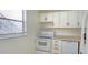 Cozy kitchen features white appliances, cabinets, and laminate countertops at 1504 Virginia Ave # 105, Daytona Beach, FL 32114