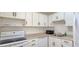 Cozy kitchen features white appliances, cabinets, and laminate countertops at 1504 Virginia Ave # 105, Daytona Beach, FL 32114