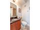 Bathroom featuring a tiled shower, granite counters, and cherry-stained vanity cabinet at 1521 Chatfield Pl, Orlando, FL 32814