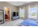 This bedroom features an ensuite bath, a large flatscreen, and oversized windows at 1521 Chatfield Pl, Orlando, FL 32814