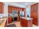 The kitchen features stainless appliances, cherry cabinets, granite counters, and an island at 1521 Chatfield Pl, Orlando, FL 32814