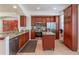Bright kitchen features stainless appliances, cherry cabinets, granite counters, and an island at 1521 Chatfield Pl, Orlando, FL 32814